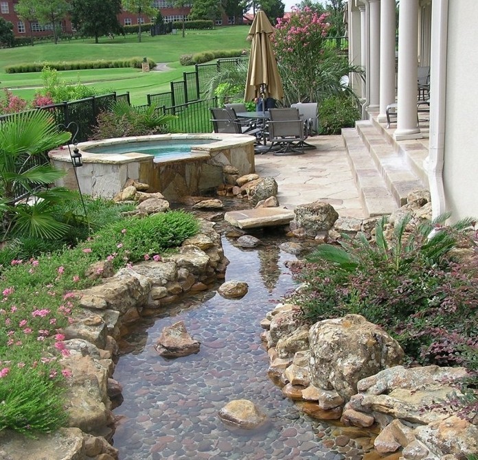 un-petit-bassin-d-eau-à-coté-de-l-entrée-d-une-maison-pierres-grosse-pierre-decoration-jardin-et-plantes-rocaille-vertes-idée-coin-zen-dans-un-jardin