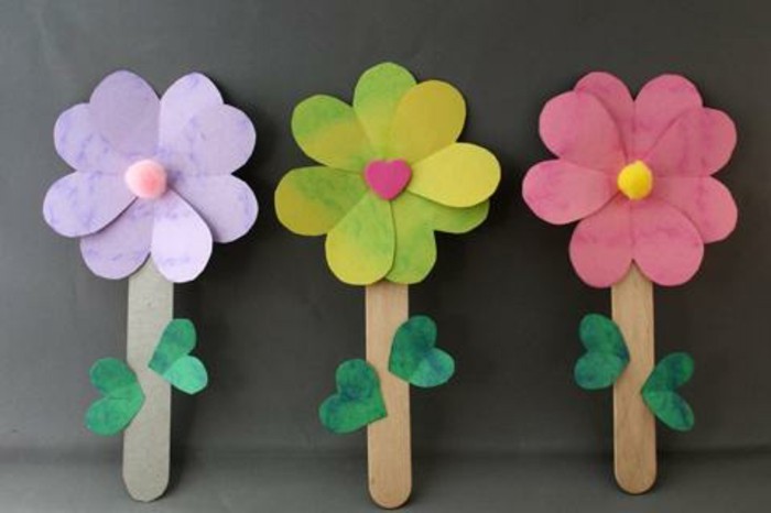 des fleurs en papier avec des batonnets de glace en guise de tiges et feuilles en papier vertes, idée activité manuelle printemps maternelle