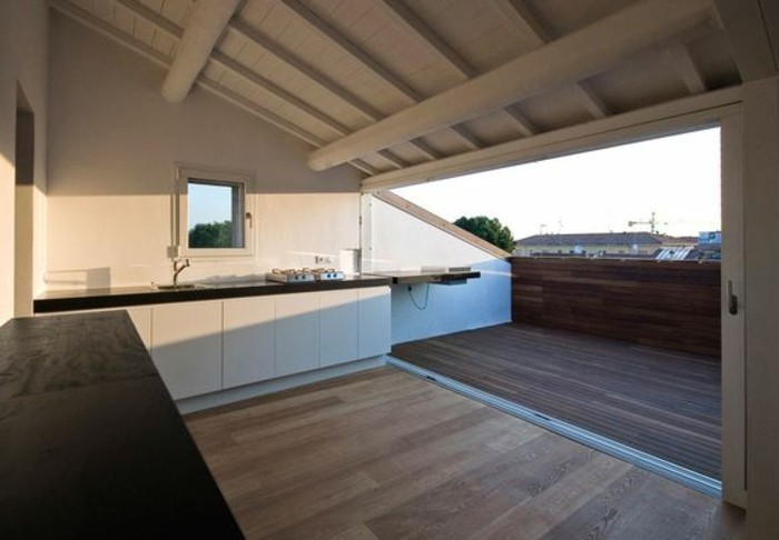 une cuisine ouverte sur une tropezienne terrasse non aménagée avec vue sur les combles, paysage urbain
