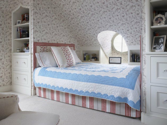 amenager comble, chambre à coucher sous les toits, papier peint motif floraux, shabby chic, lit sous pente en rouge et blanc, couverture de lit en blanc et bleu, tapis blanc, meuble mansarde blanc
