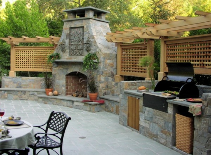 une cuisine exterieure en pierre avec barbecue et cheminée