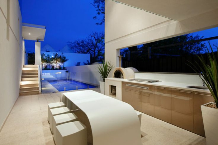 un patio moderne avec espace piscine et une cuisine d'extérieur aux lignes élégantes