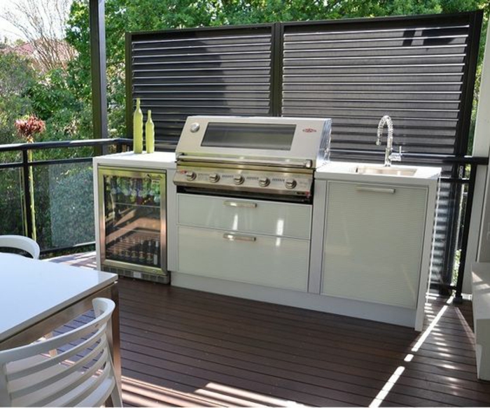 une cuisine d'été couverte à barbecue et mini frigo, rangements couverts ingénieux