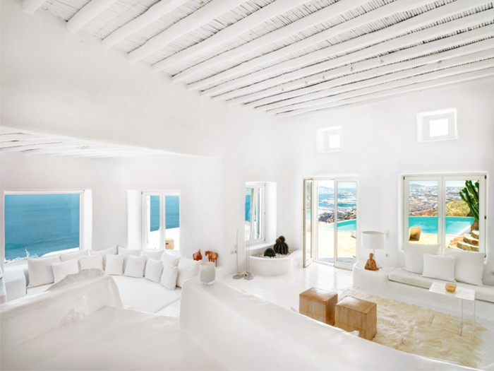 décoration grecque, plafond avec poutres en bois, fenêtres sur la mer, murs blancs