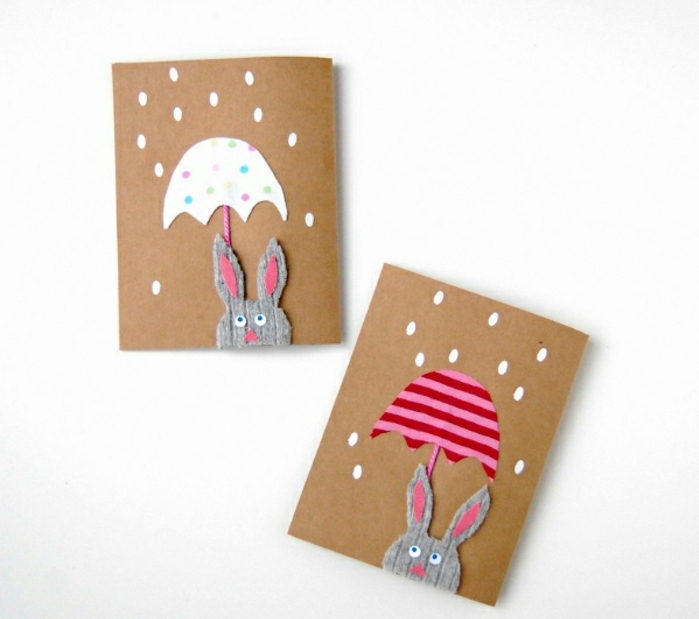 carte joyyeuses paques en papier kraft, lapin de paques en tissu gris, parapluie blanc à points et parapluie à rayures rose et rouges