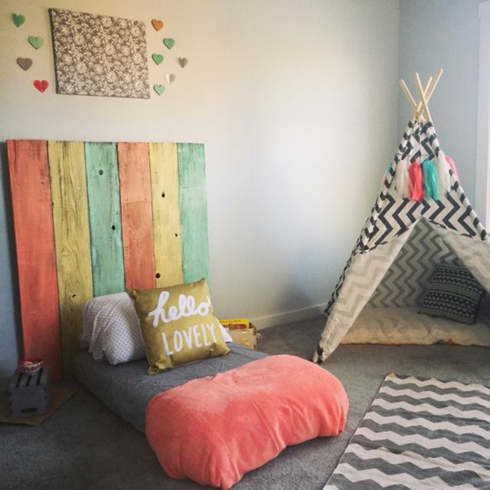 mur couleur gris clair, lit bébé montessori, tête de lit de planches en bois colorées, tapis gris, titpi enfant, méthode montessori aménagement chambre enfant