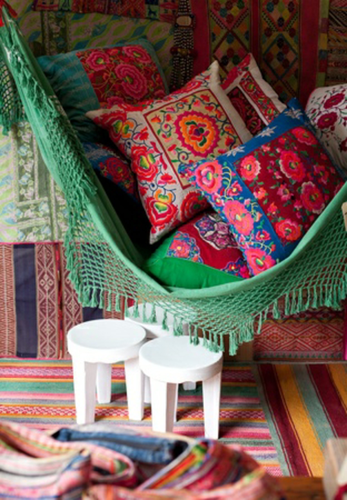 deco boheme, hamac vert avec franges, coussins décoratifs, tapis multicolore