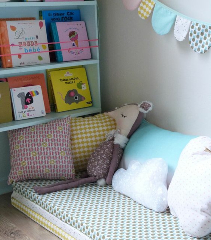 lit bébé montessori, matelas au sol, coussins multicolores, rangement etageres livres, guirlande en tissu