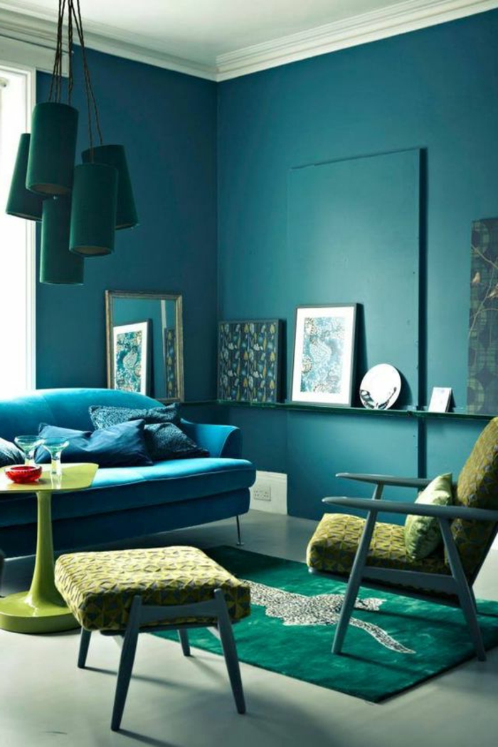 mur couleur canard, lampes bleues pendantes, sofa bleu, table verte, porte encadrement 