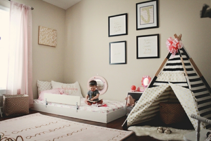 chambre montessori, lit au sol, titpi en enfant, rayures noir et blanc, ruban rose, tapis de jeu, deco murale, parquet stratifié marron