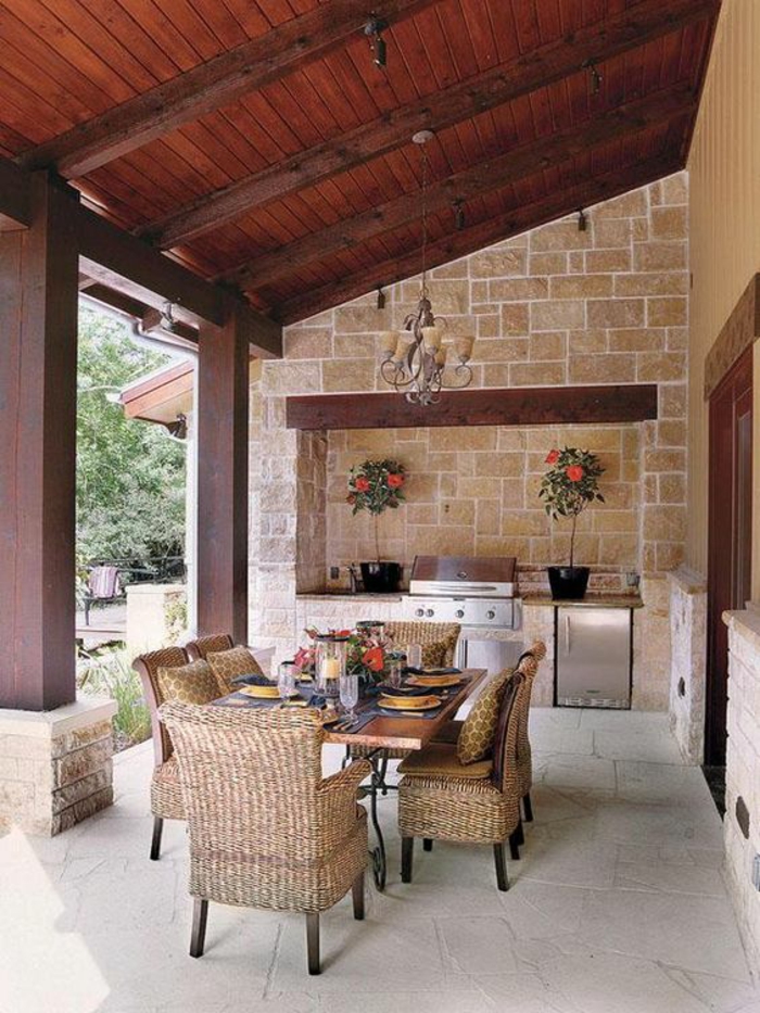 une véranda en pierre à un abri bois, une cuisine exterieure en pierre nichée dans le mur