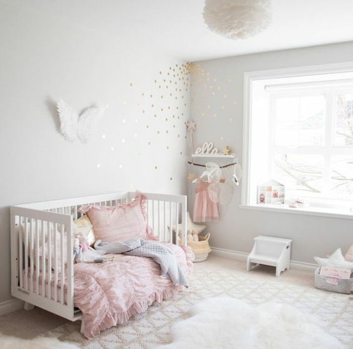 mur couleur gris clair, lit b;ébé blanc, linge de lit rose, gris et blanc, tapis blanc à motifs triangles, idée déco chambre petite fille, suspension design blanche