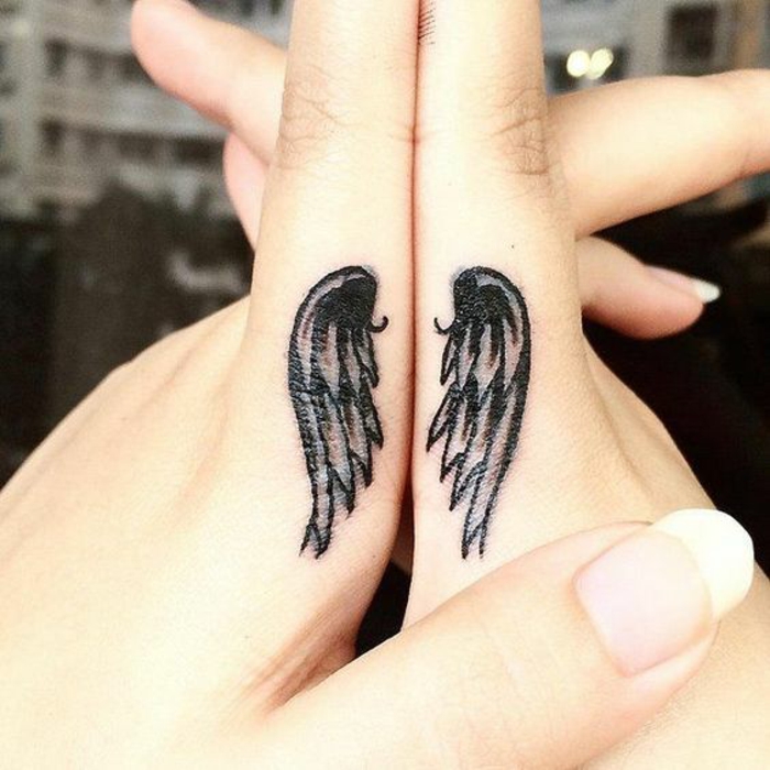 une petite paire d'aile tatouée sur le côté des index, idée originale de tatouage sur les doigts