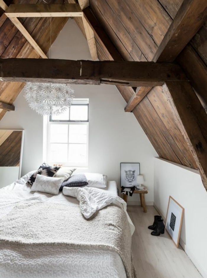 chambre mansardée, comble aménagé en chambre style scandinave, linge de lit blanc, miroir, coussins en noir et blanc, deco suspendue, toiture en bois