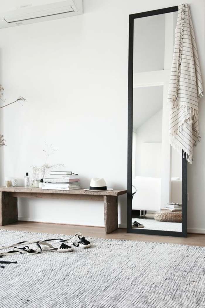 déco minimaliste, grand miroir rectangulaire et une banquette en bois