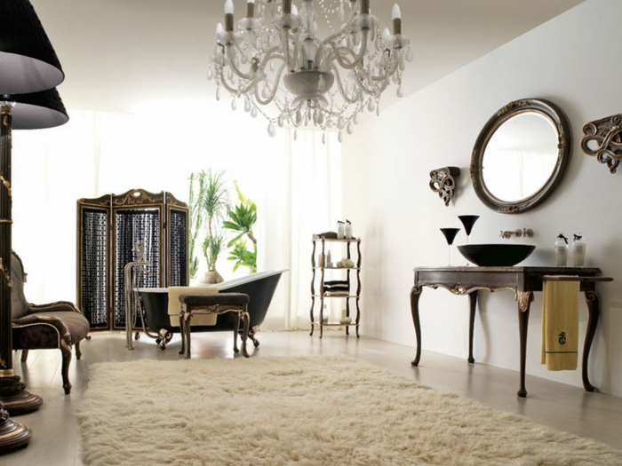deco baroque, tapis blanc moelleux, lustre en cristaux, miroir rond, plantes vertes, baignoire noire
