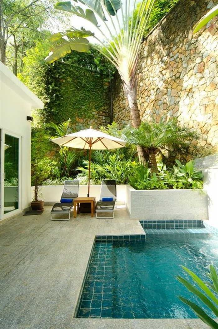 jolie piscine verte dans une ambiance tropicale, entourage piscine en pierre