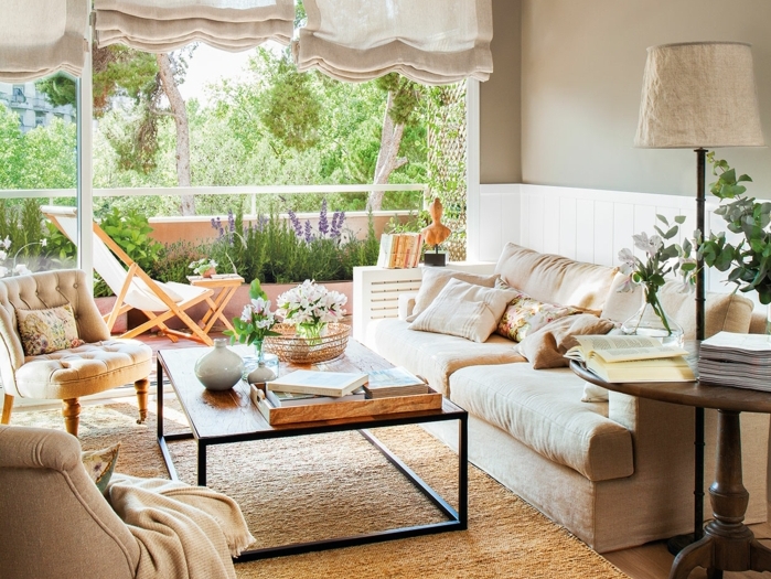home staging, tapis beige moelleux, vue sur le jardin, lampe beige, murs en gris pâle, fleurs vertes