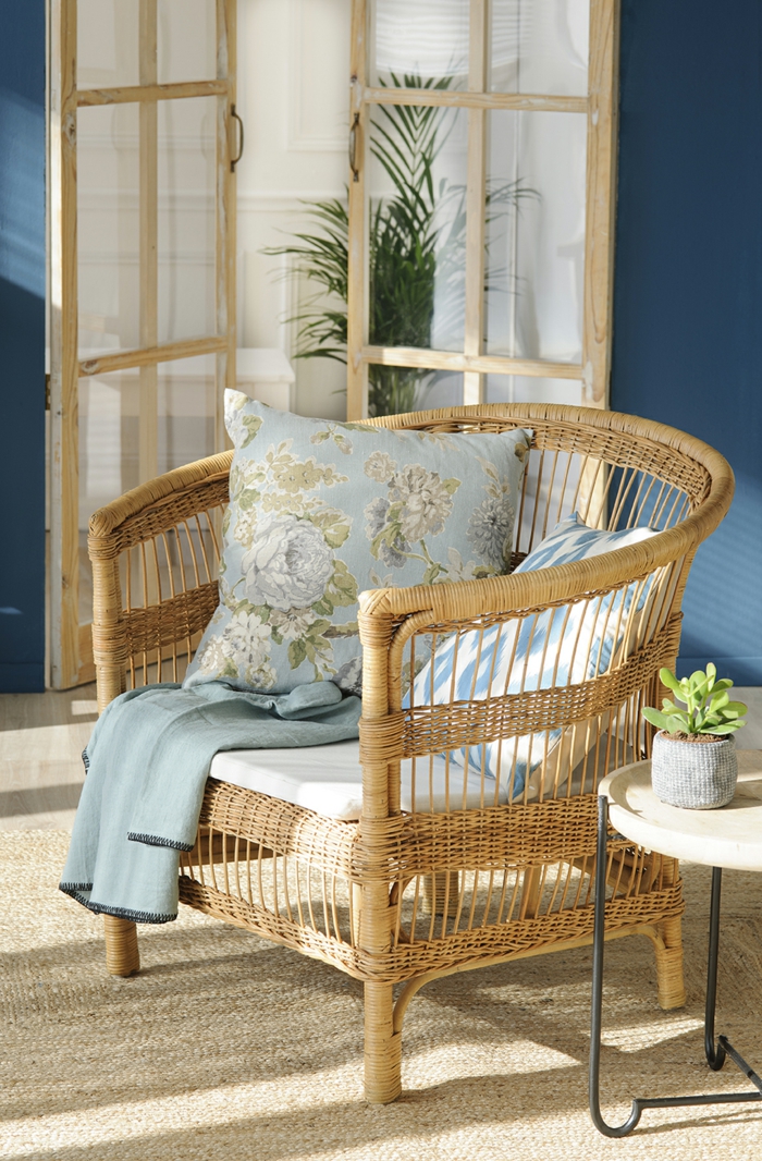 formation home staging, chaise en rotin, coussins vintage, murs en bleu foncé, petite table ronde en bois et fer forgé