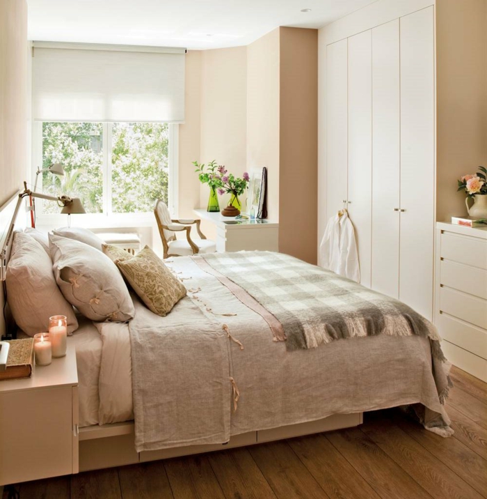 lit douillet, grande fenêtre, bouquet de fleurs, couverture de lit taupe