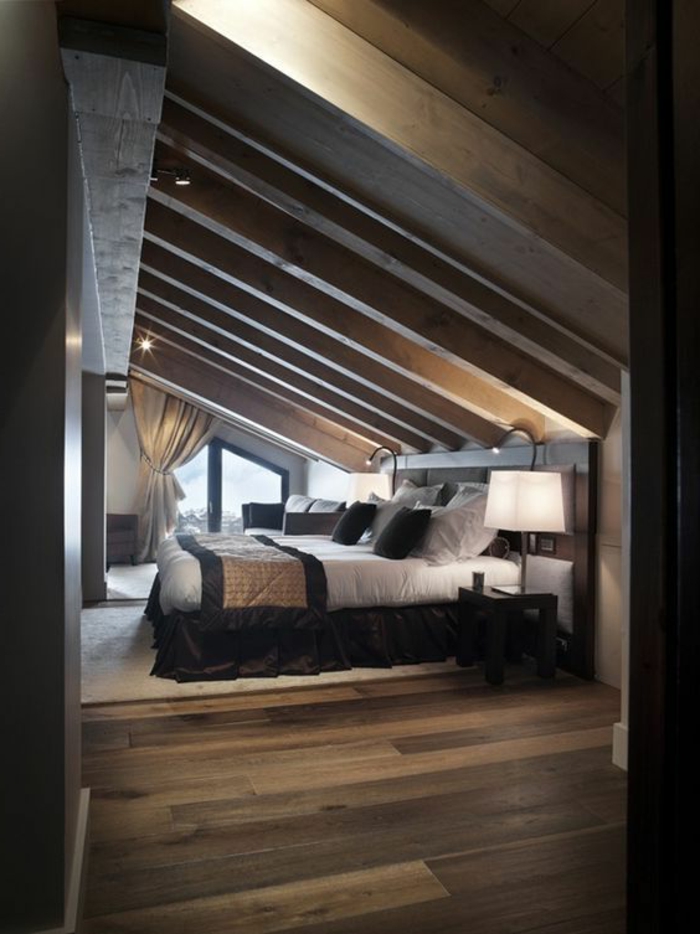 lit en bois, toit en bois, tapis blanc cassé, parquet stratifié marron, linge de lit blanc et noir, déco chambre sous pente