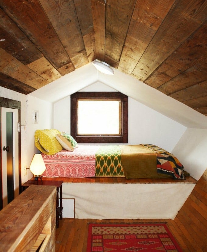 toiture planche de bois, matelas en hauteuil, linge de lit multicolore, motifs orientaux, tapis oriental, commode en bois, amenagement combles