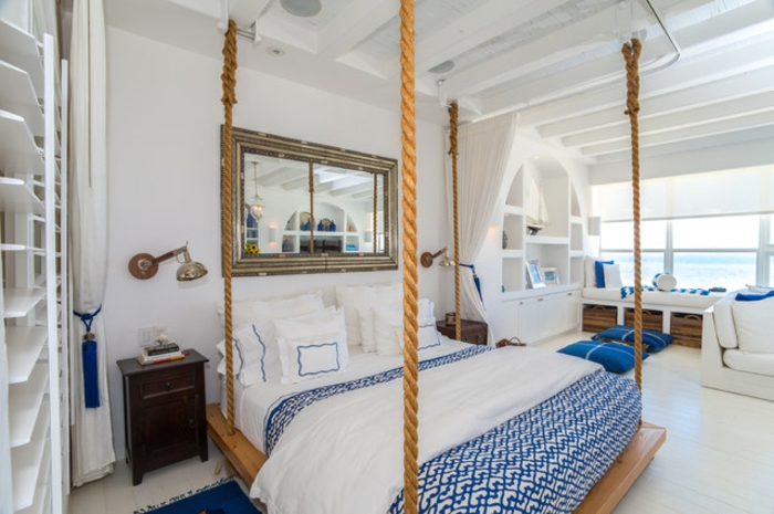 bleu grec, lit suspendu, grand miroir, tapis bleu foncé, couverture de lit en blanc et bleu