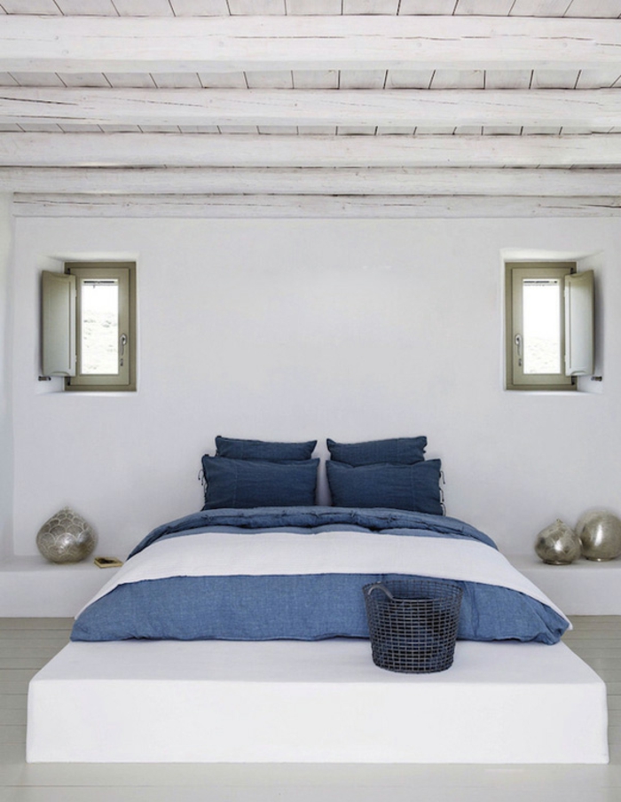 bleu grec sur le lit, petits volets en vert, plafond en bois, murs blancs