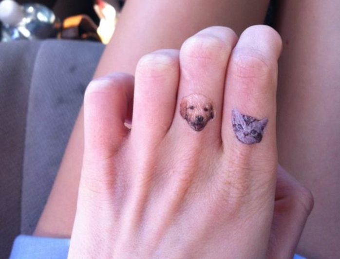 un tatouage sur le doigt original à tête de chat et de chien, tatouage coloré minimaliste