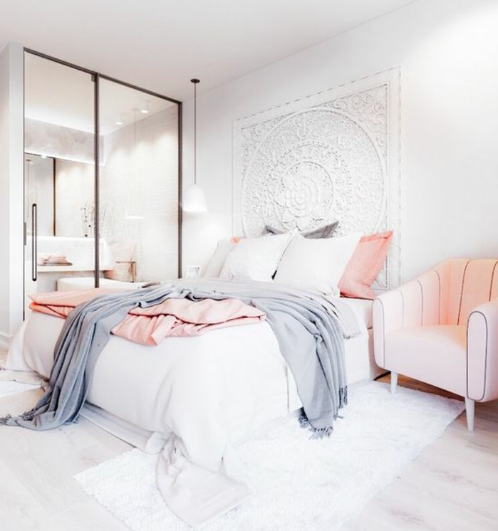 couleur mur blanc et deco murale oriuentale blanche, tapis blanc, canapé rose quartz, parquet clair, coussins et linge de lit gris, rose quartz et blanc, chambre rose et gris ouverte sur une salle de bain