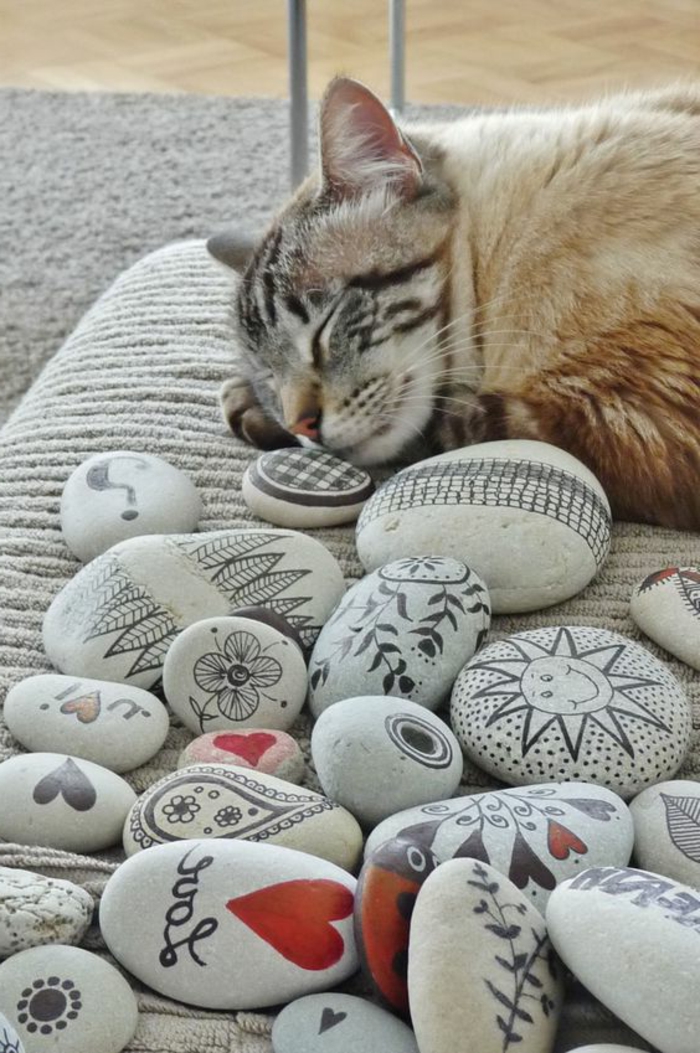peindre des galets, chat qui dort et plusieurs galets décorés 