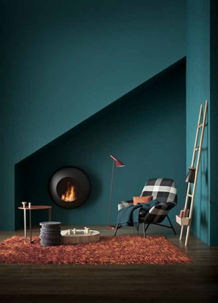 peinture bleu canard, tapis rouge, cheminée ronde décorative, échelle en bois 