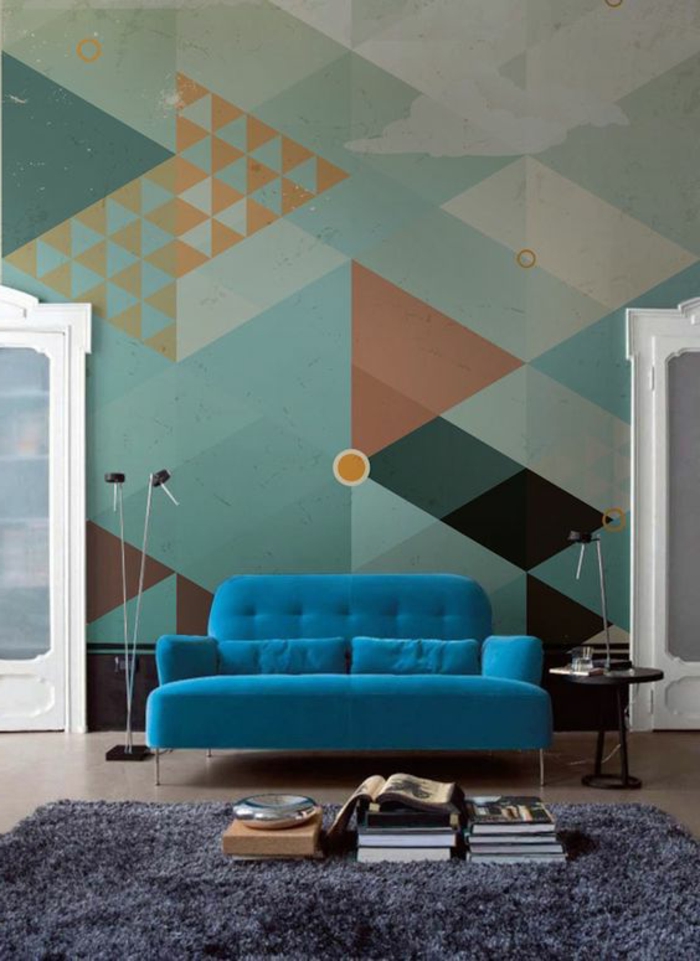 peinture murale, motifs triangulaires aux murs, sofa bleu et tapis gris 
