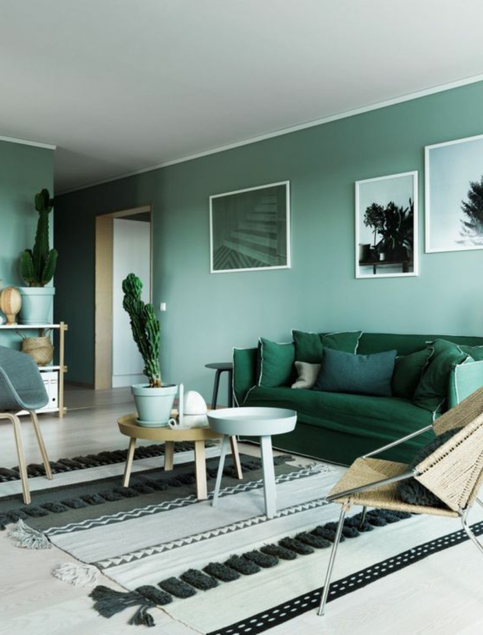 peinture murale verte, sofa vert, tapis monochrome, plusieurs coussins verts 