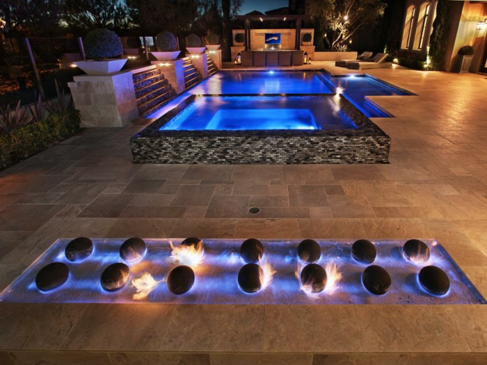 piscine surélevée, cascades d'eau, décoration feu, éclairage piscine en bleu, piscine hors sol