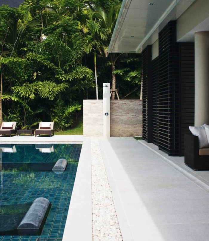 piscine au design contemporain et au revêtement de sol en carreaux vertes, entourage piscine en pierre reconstituée
