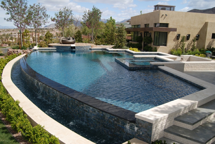 piscine hors sol, cascades d'eau, façade de maison beige, piscine surélevée