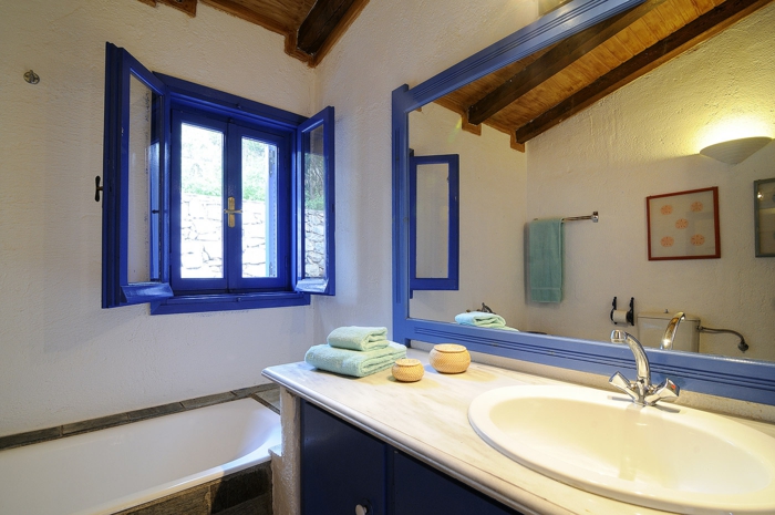 décoration grecque, volets en bleu foncé, plafond en bois, grand miroir, lavabo en marbre