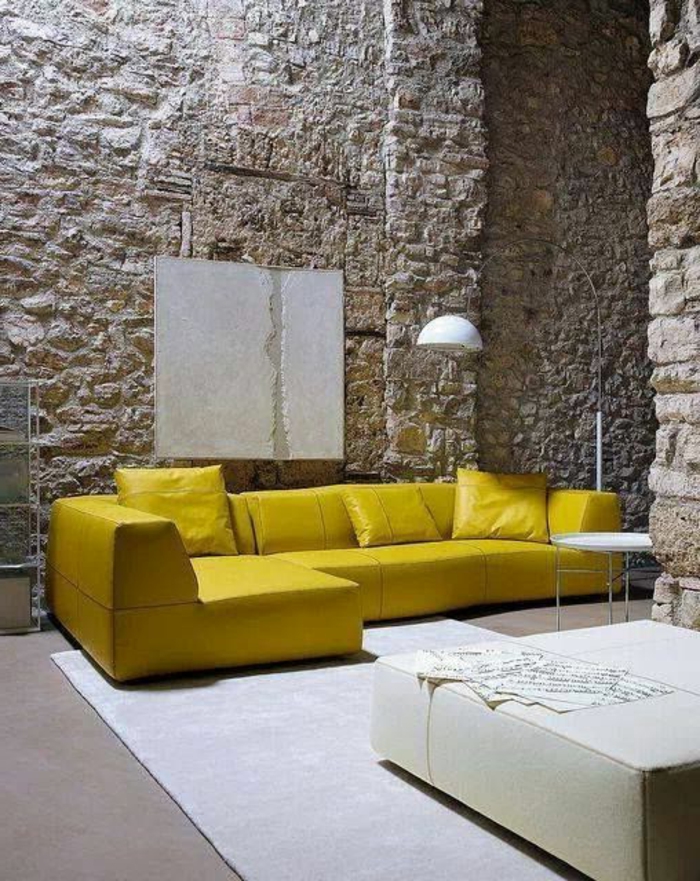 salon gris et jaune, mur en pierre apparente, canapé jaune 