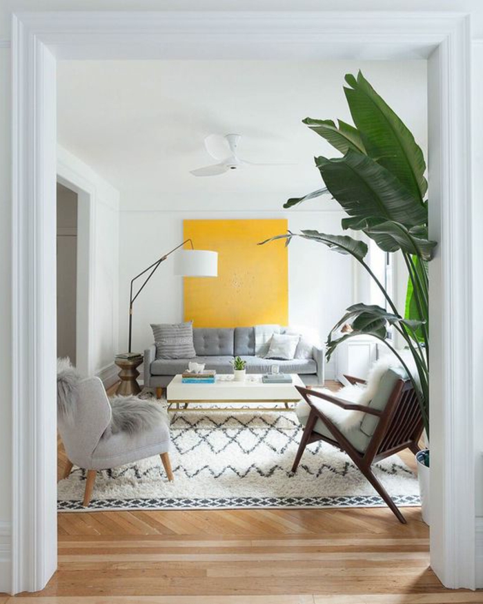 salon gris et jaune, tapis marocain, tableau jaune, grande plante et table basse blanche 