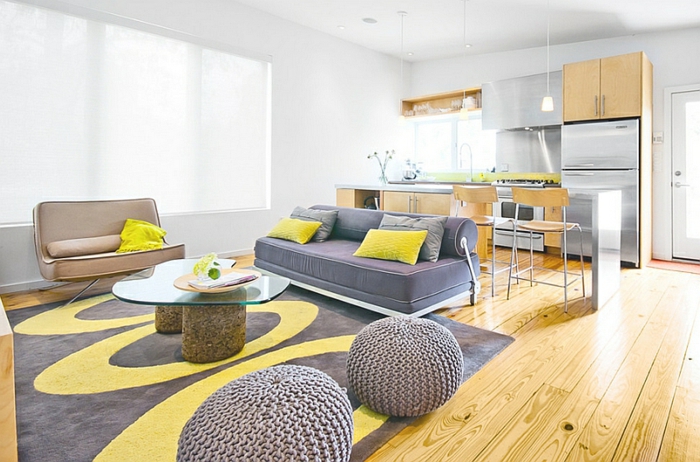 salon jaune et gris, tapis bicolore en jaune et grisn poufs tricotés, cuisine à plan ouvert