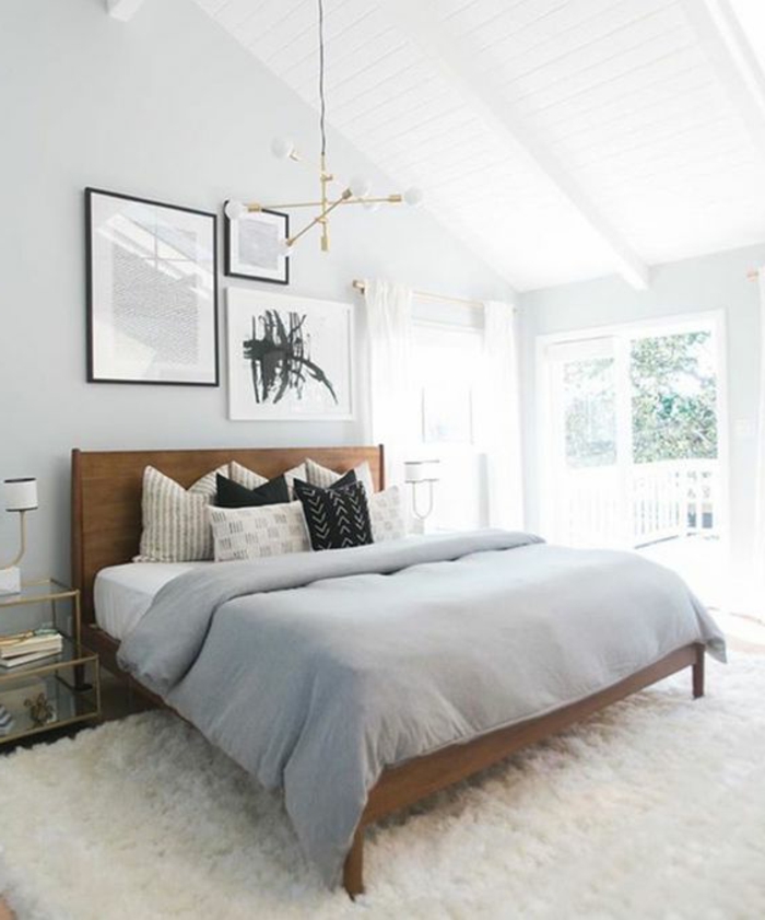 tapis blanc, lit en bois, couverture de lit grise, coussins en blanc, gris et noir, couleur mur blanc, suspension design, tableaux decoratifs