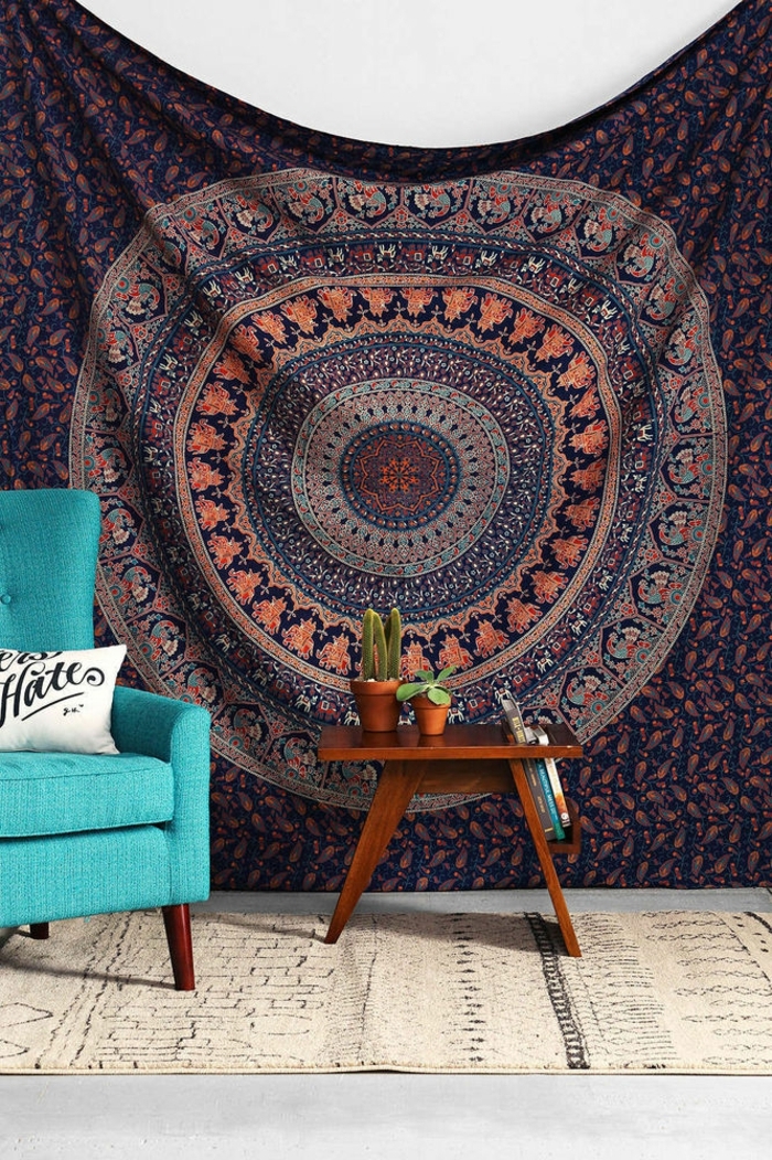 chambre hippie, fauteuil turquoise, table en bois, tapis beige, teinture murale
