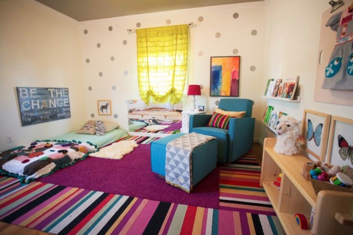 mur couleur blanche, points gris, etageres rangement livres, tapis multicolores, fauteuil blei, lit bébé montessori au sol, style bohème, jouets, décorations