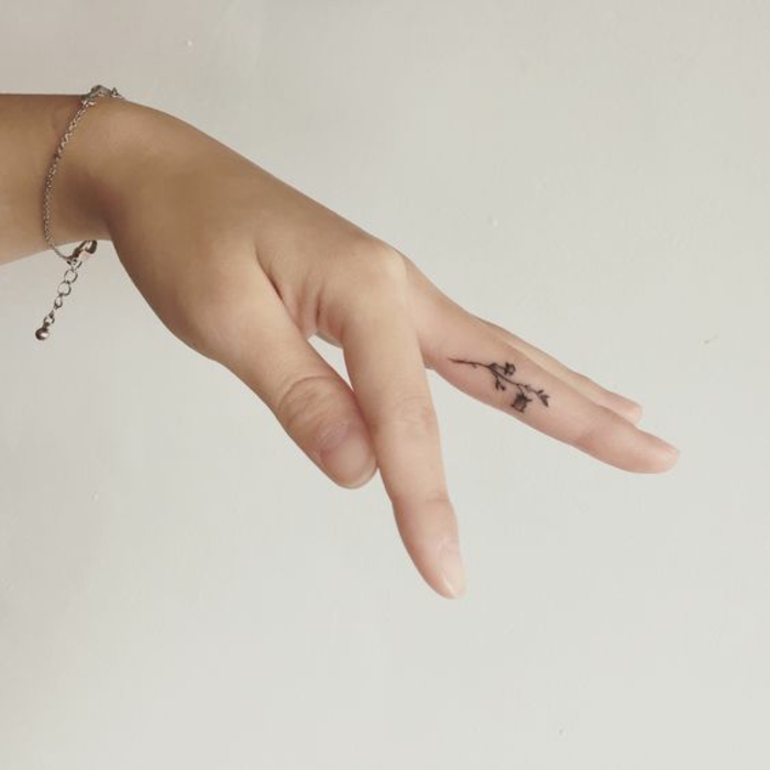  un tatouage sur le doigt minimaliste à motif fleuri, tatouage subtil et féminin