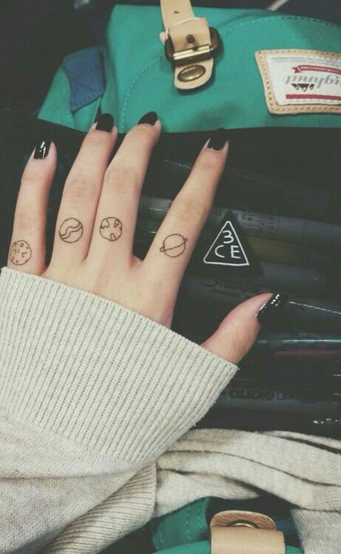 un tatouage sur les doigts à motif planètes, tatouage à la fois simple et original 