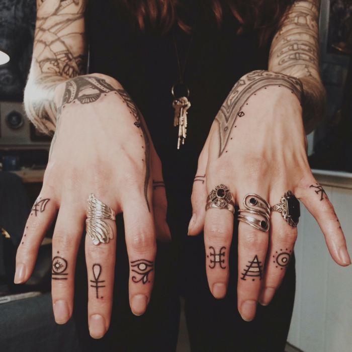 un tatouage main à symboles égyptiens, des tatouages géométriques sur chaque doigt