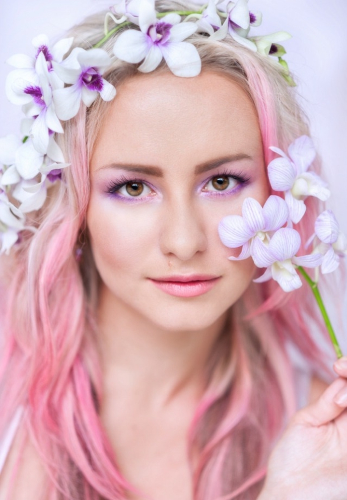 cheveux blond rose, coiffure mi-long avec mèches rose pastel, couronne en fleurs, maquillage violette
