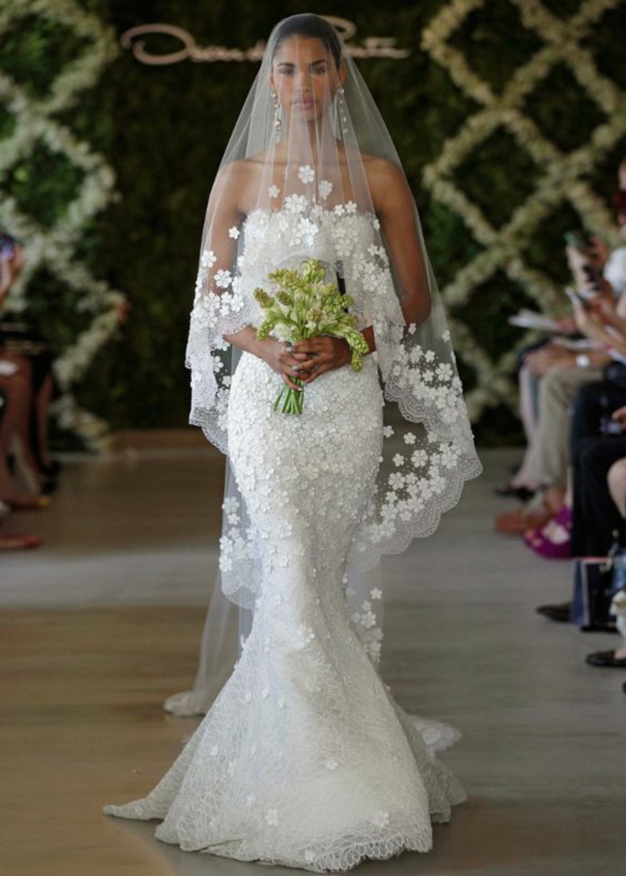 une élégante robe de mariée sirène en dentelle associée avec voile mariée brodé à finition dentelle