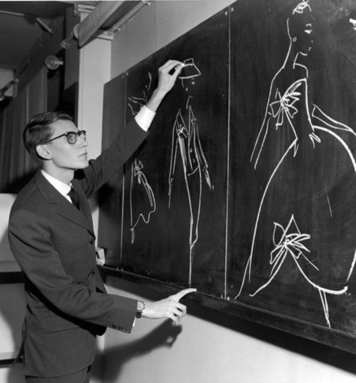 année 60, Yves Saint Laurent dessinant ses modèles sur un tableau noir